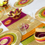 table en extérieur décorée avec des sets, un chemin de table et panières
