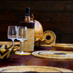 table décorée avec des sets ronds, panière, verres et porte-bouteille