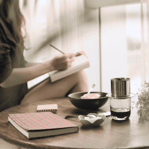 sanctuaire sur une table, avec un carnet, une tasse et une bougie posés dessus